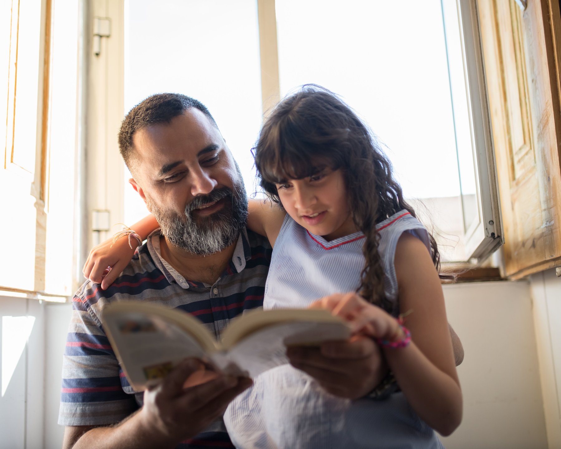 A father reading a book together with his daughter