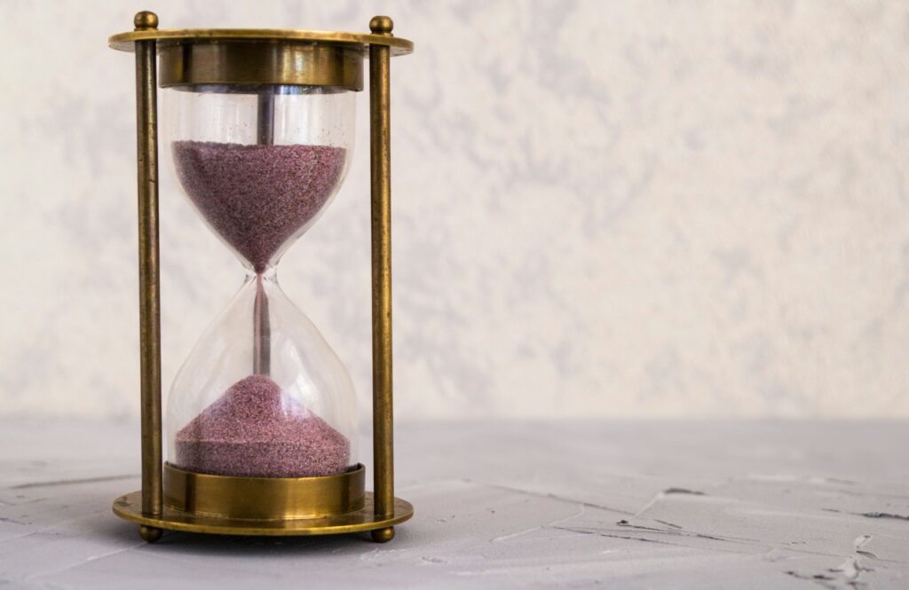 An hourglass on a golden frame, symbolising waiting
