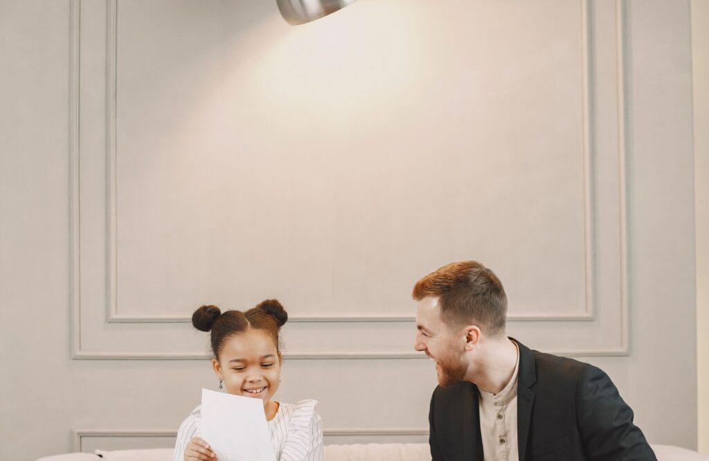 A man smiling with a young girl during a friendly assessment session